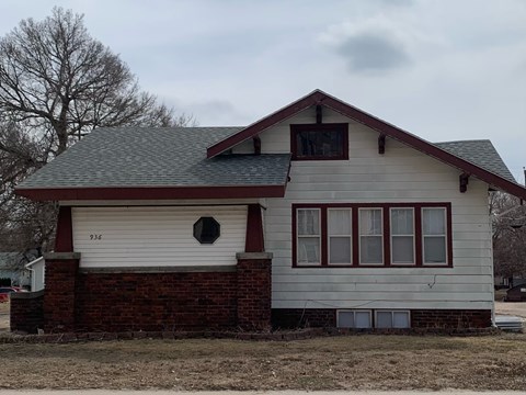 a white house with a brick wall and a gray roof