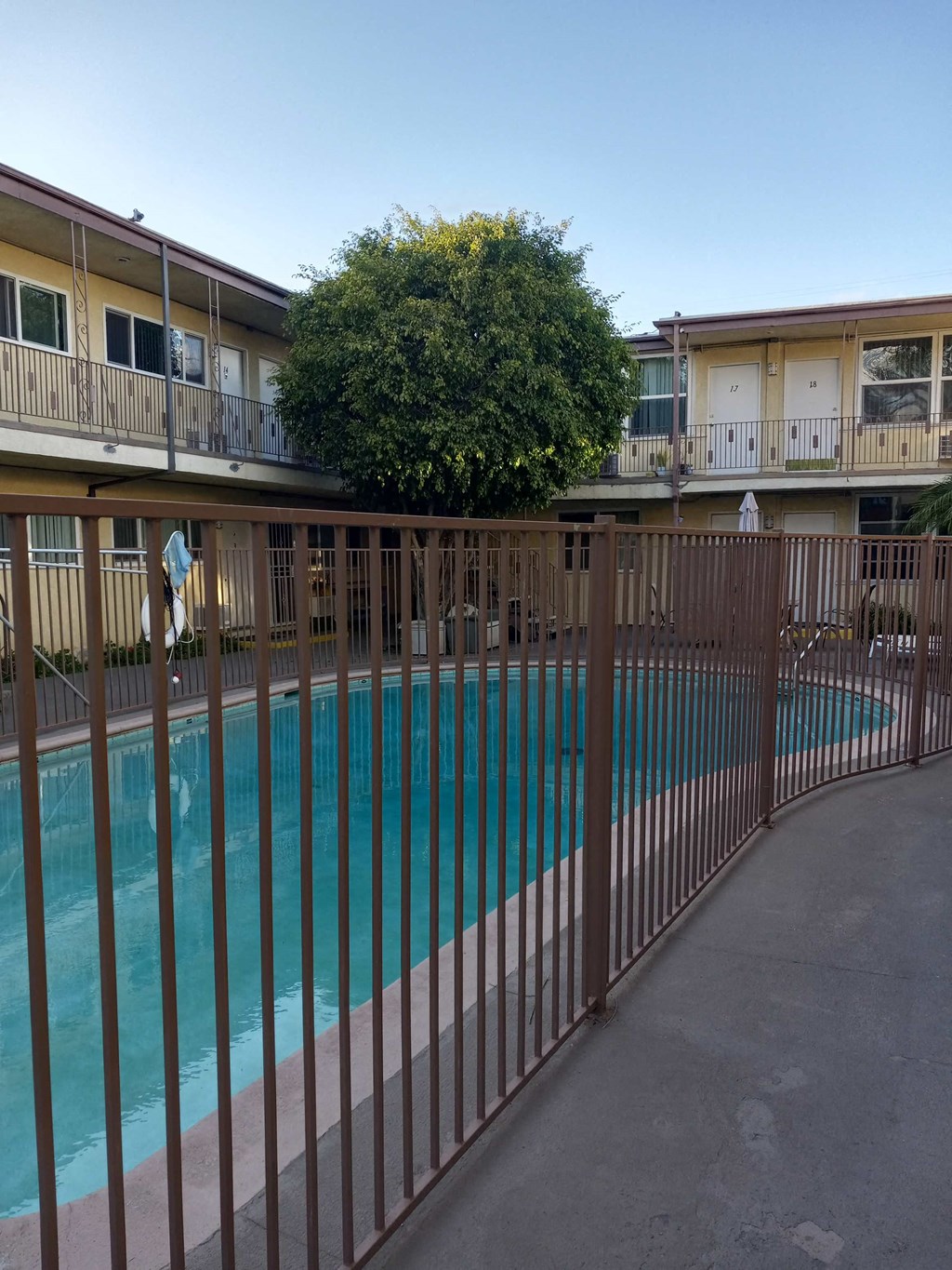 the pool is behind a fence in front of an apartment building