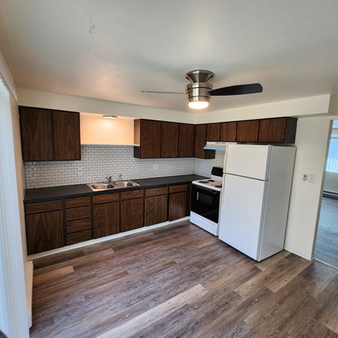 A kitchen with wooden cabinets and a white refrigerator.