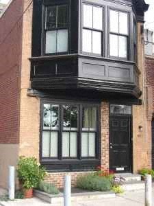 A black and white building with a black door and windows.
