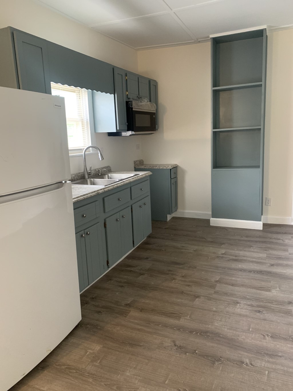 a kitchen with white appliances and blue cabinets
