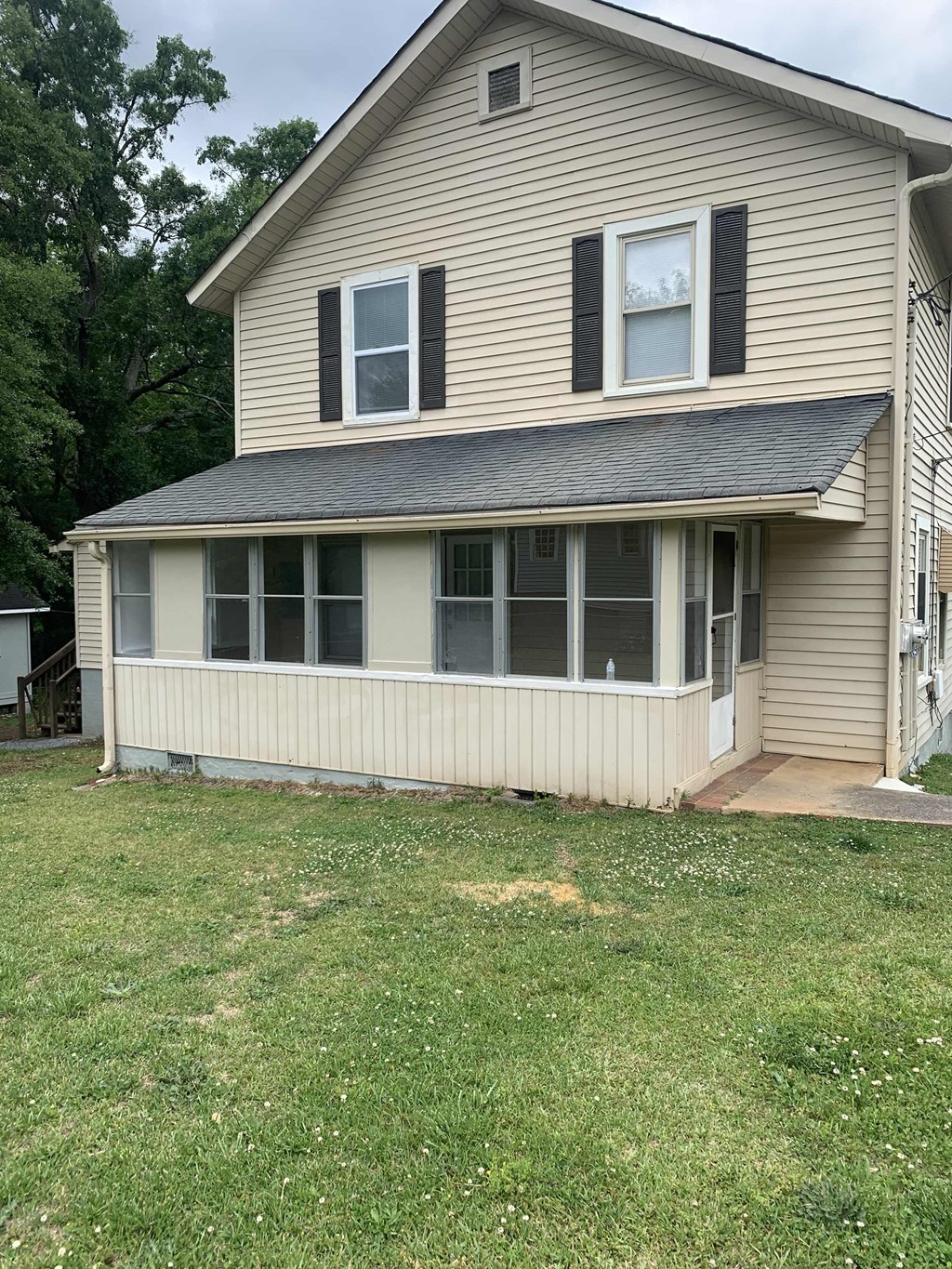 a yellow house with a white fence and a lawn