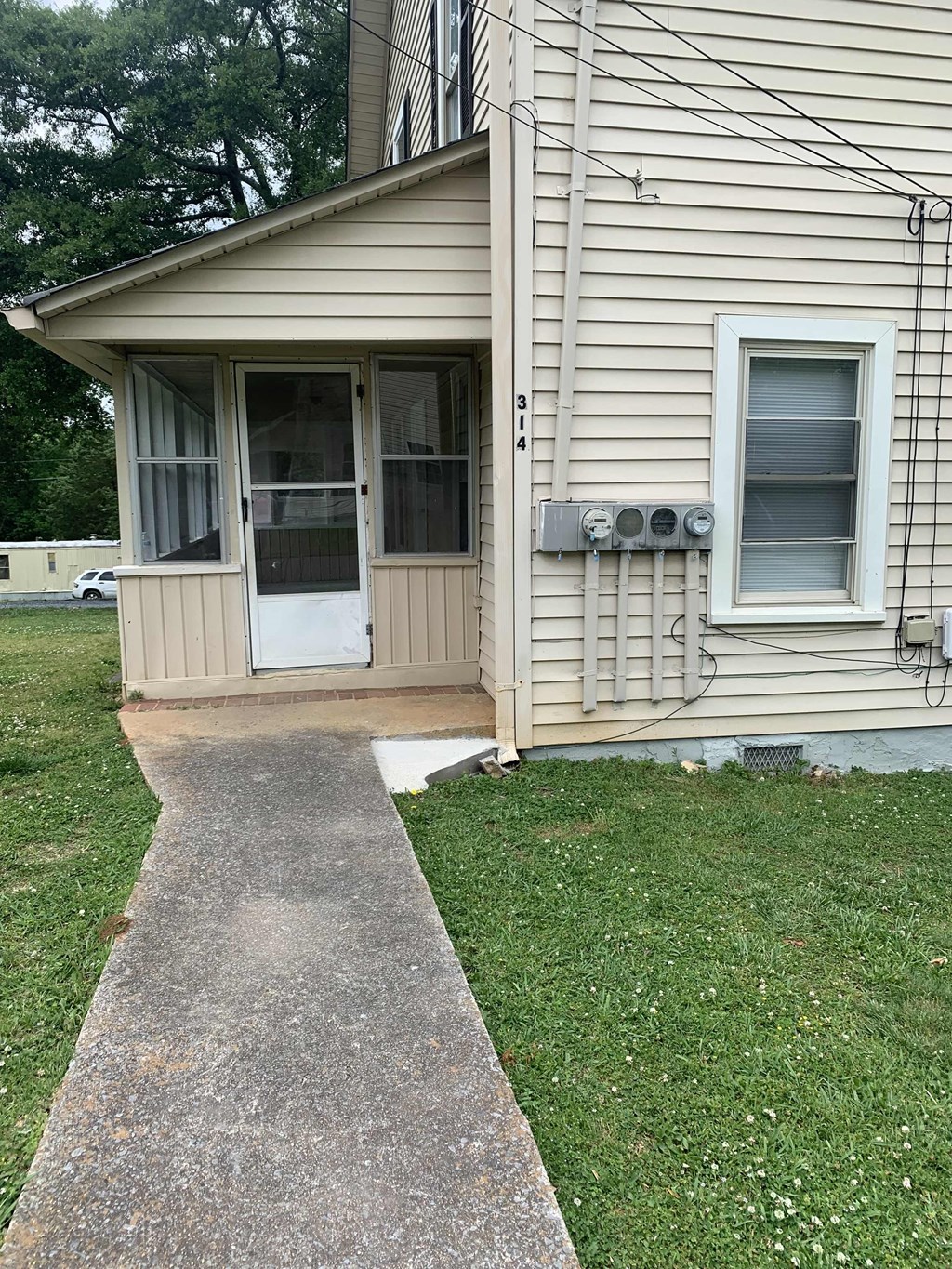 a front porch of a house with a walkway and grass