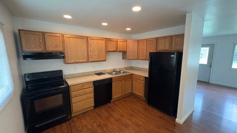 a kitchen with black appliances and wooden cabinets
