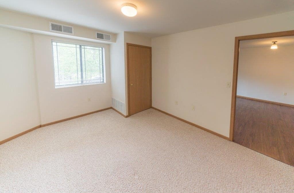 an empty room with a door and a window