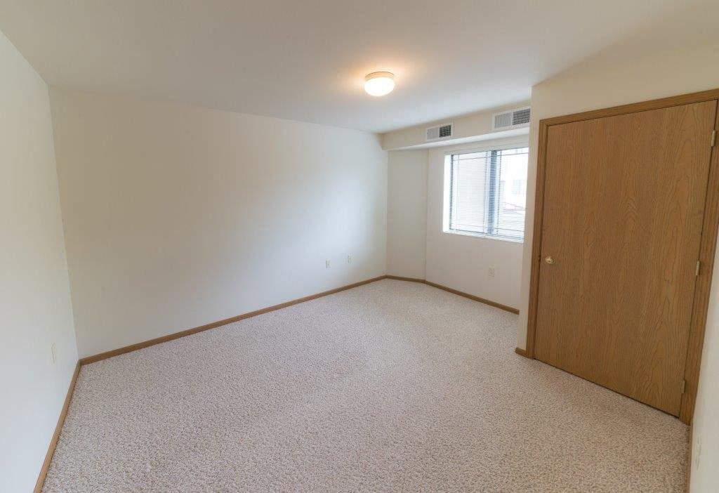 an empty room with a closet and a window
