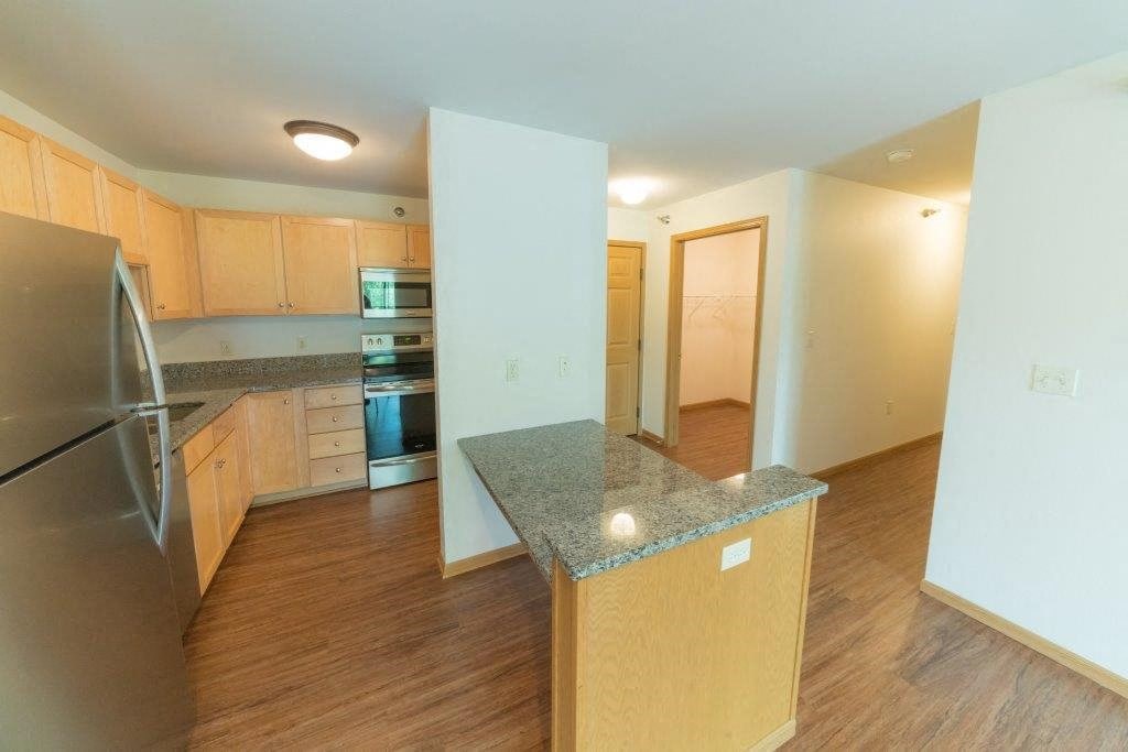 an empty kitchen with a granite counter top