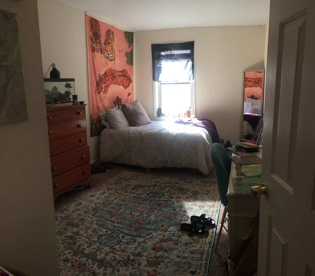 a bedroom with a bed and a dresser and a window