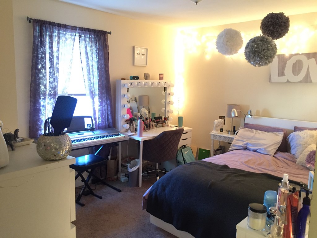 a bedroom with a bed and a desk with a keyboard