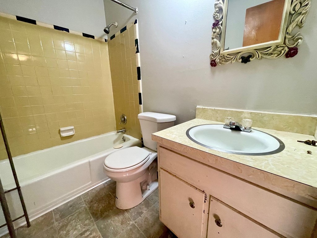 A bathroom with a toilet, sink, and bathtub.