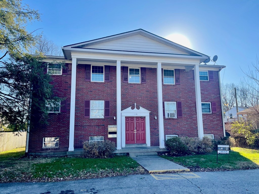 A red brick house with a white door and windows.