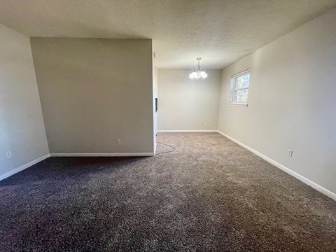 A room with a carpeted floor and a window.