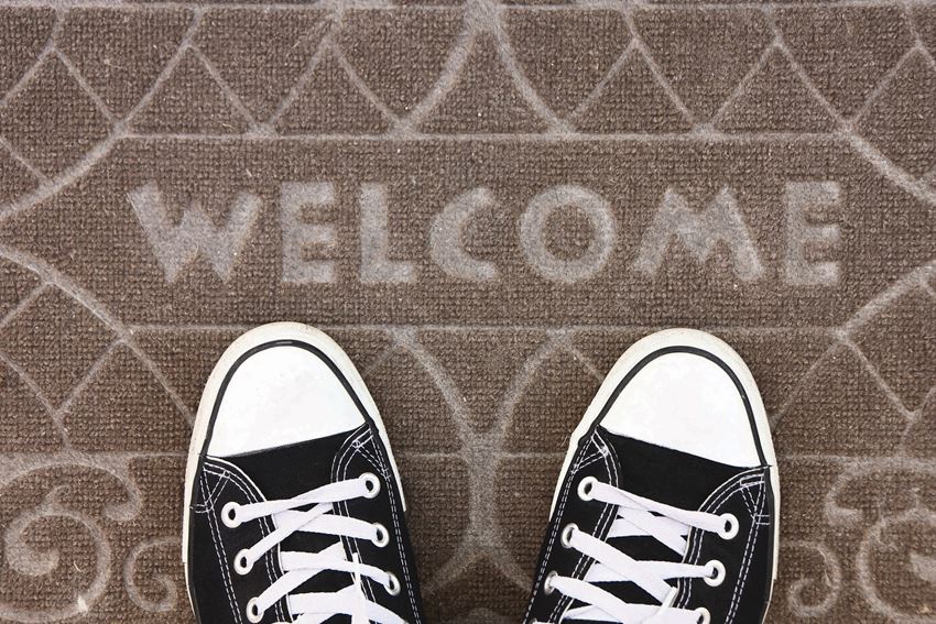 a pair of shoes on the ground with the word welcome on the floor
