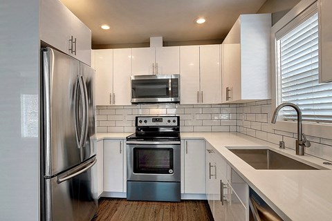 a kitchen with white cabinets and stainless steel appliances