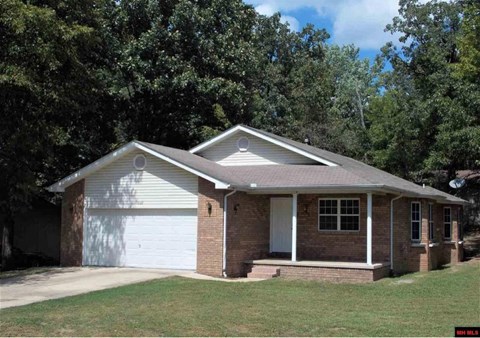 a small brick house with a white garage door