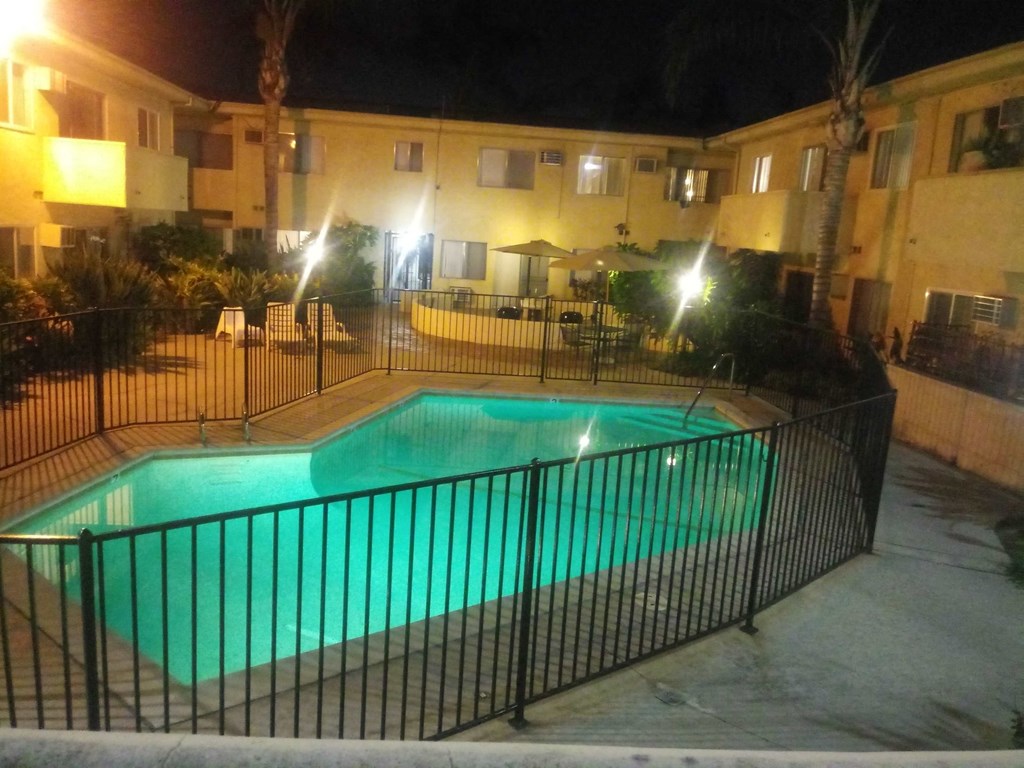 the pool is lit up at night at the resort