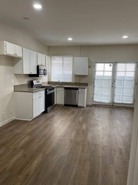 a kitchen with white cabinets and a wood floor