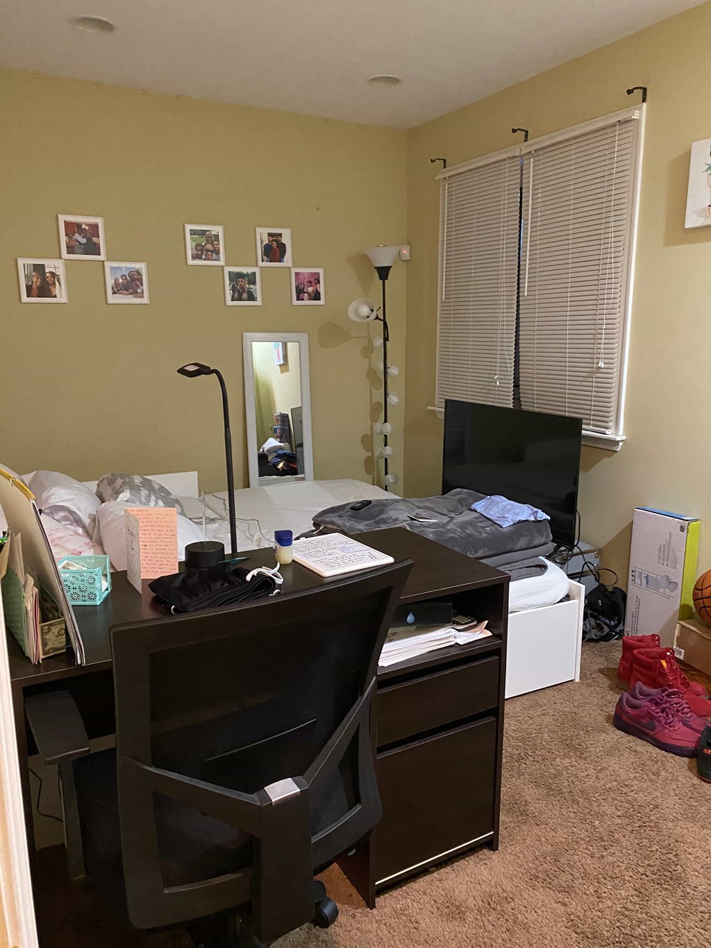 a bedroom with a desk and a tv in it
