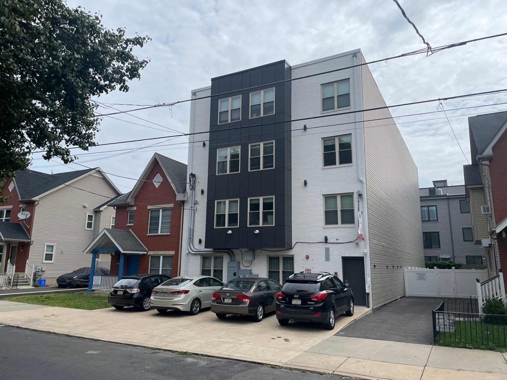 a new apartment building with cars parked in front of it