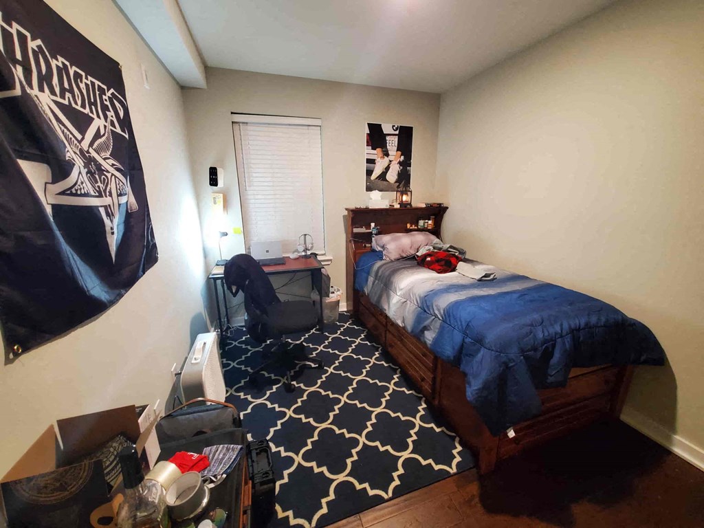 a bedroom with a bed and a desk in a small room