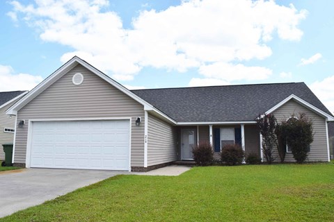 a house with a white garage door and a lawn