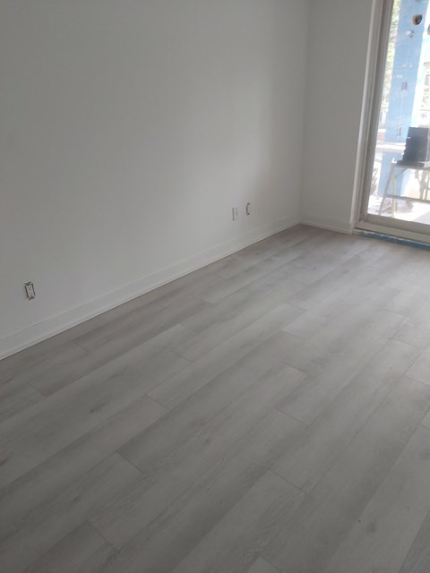an empty room with wooden floors and a window