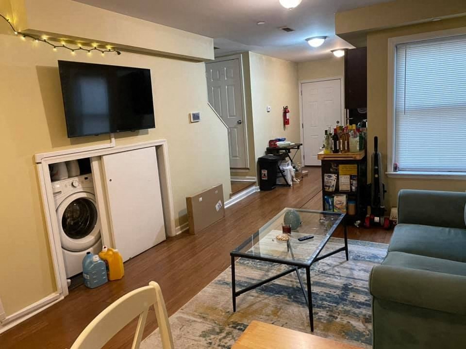 a living room with a couch and a washing machine in it
