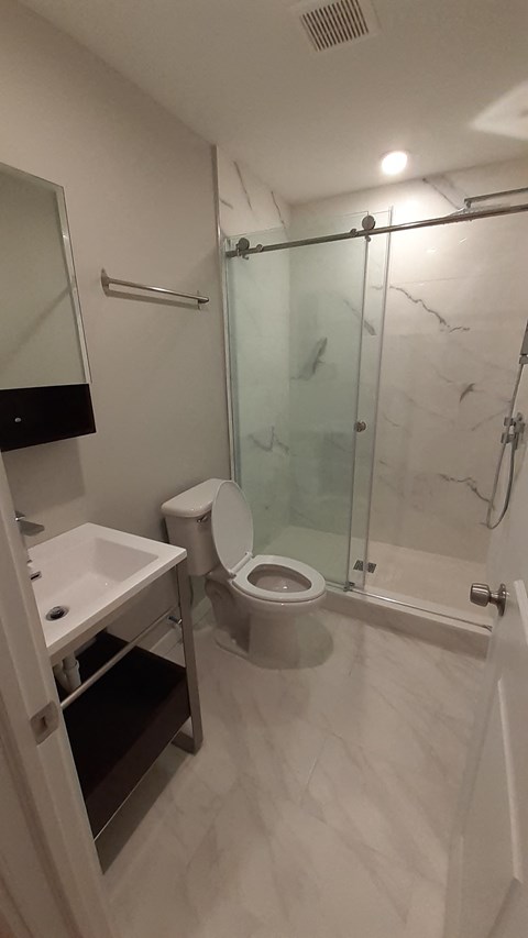a bathroom with a toilet and a sink and a shower