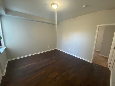 a empty living room with wooden floors and a light on the ceiling