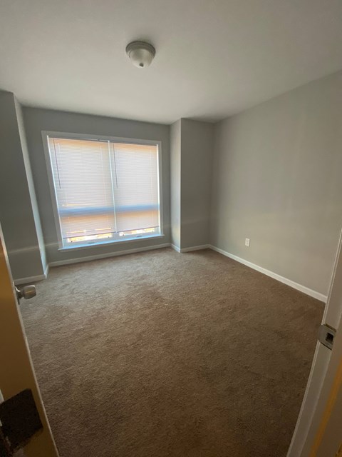 an empty room with a window and a carpet