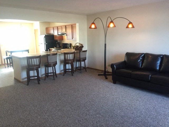 a living room and kitchen with a couch and a table
