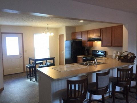 a kitchen with a bar and a dining area