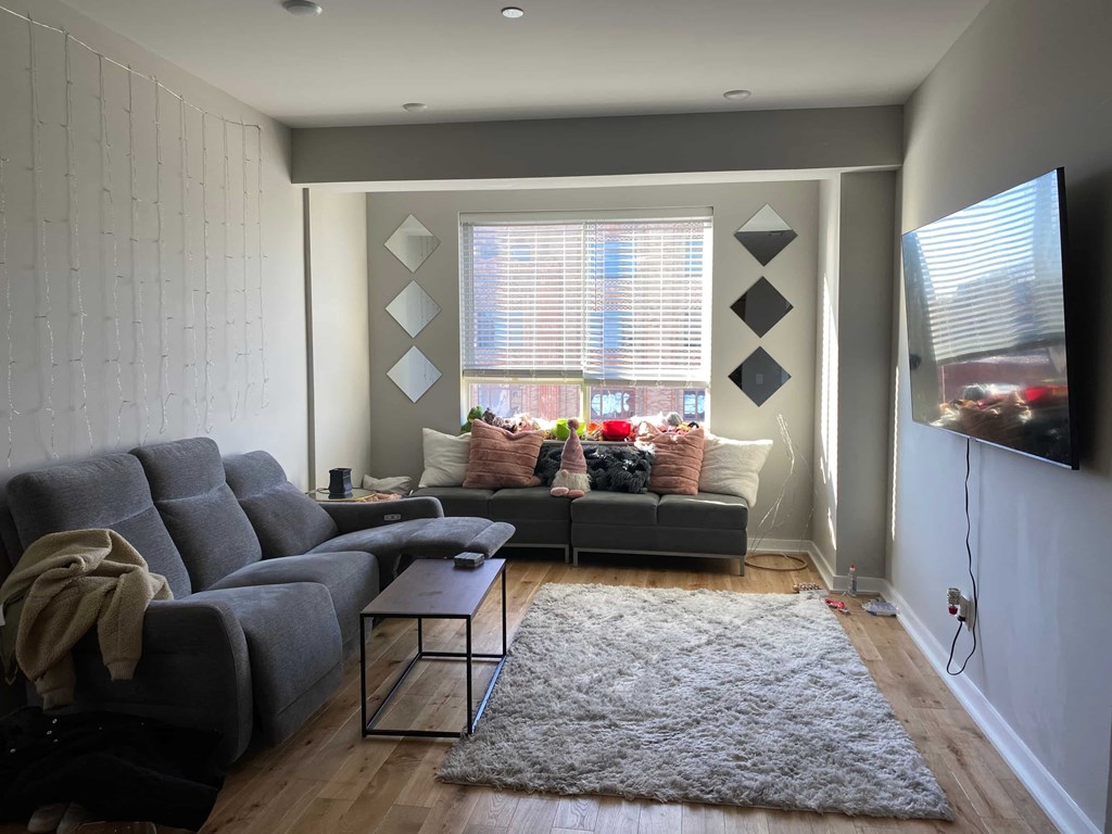 a living room with a gray couch and a window