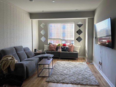 a living room with a gray couch and a window
