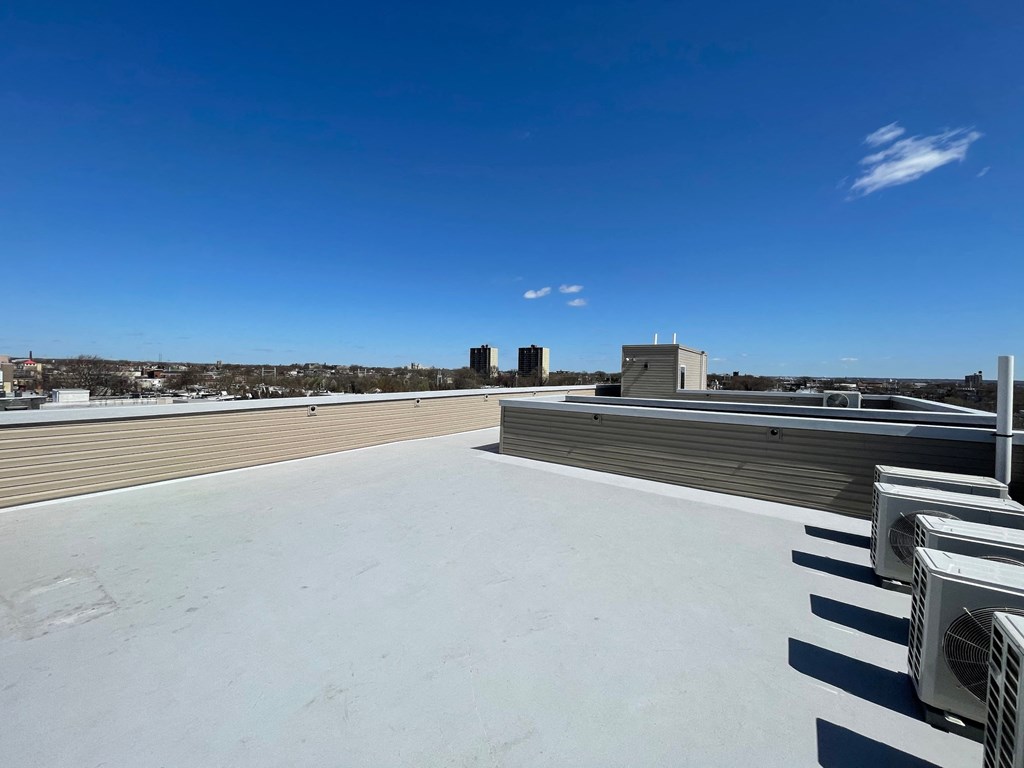 a roof with a blue sky and a city in the background