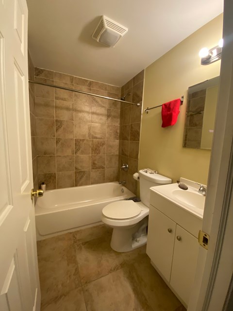 a bathroom with a toilet and a tub and a sink