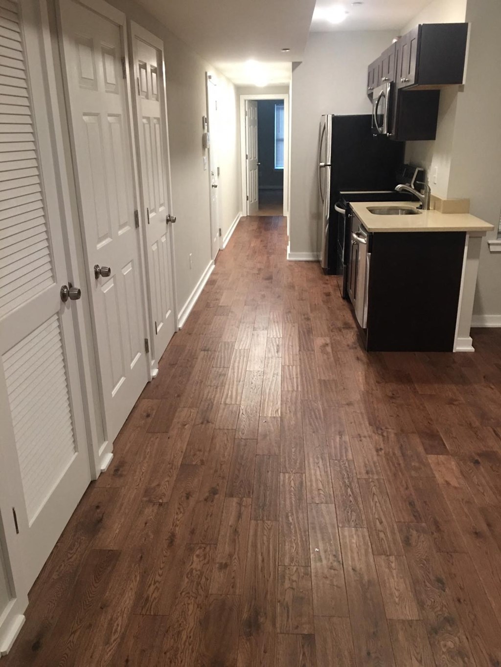 a kitchen and a hallway with wood floors