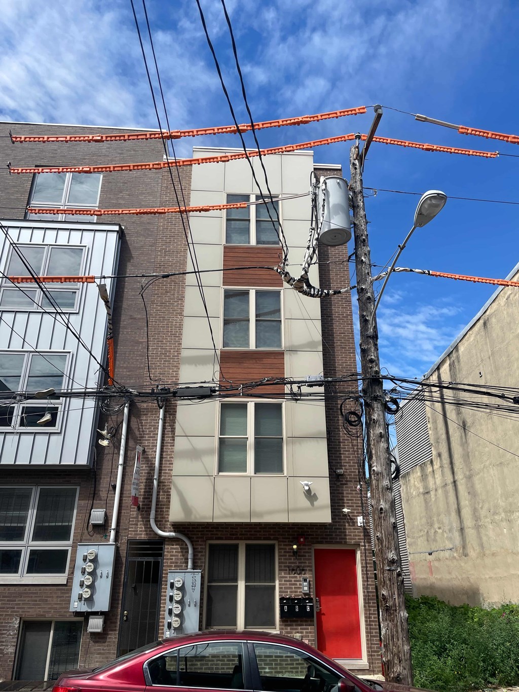 the front of a brick building with a red door