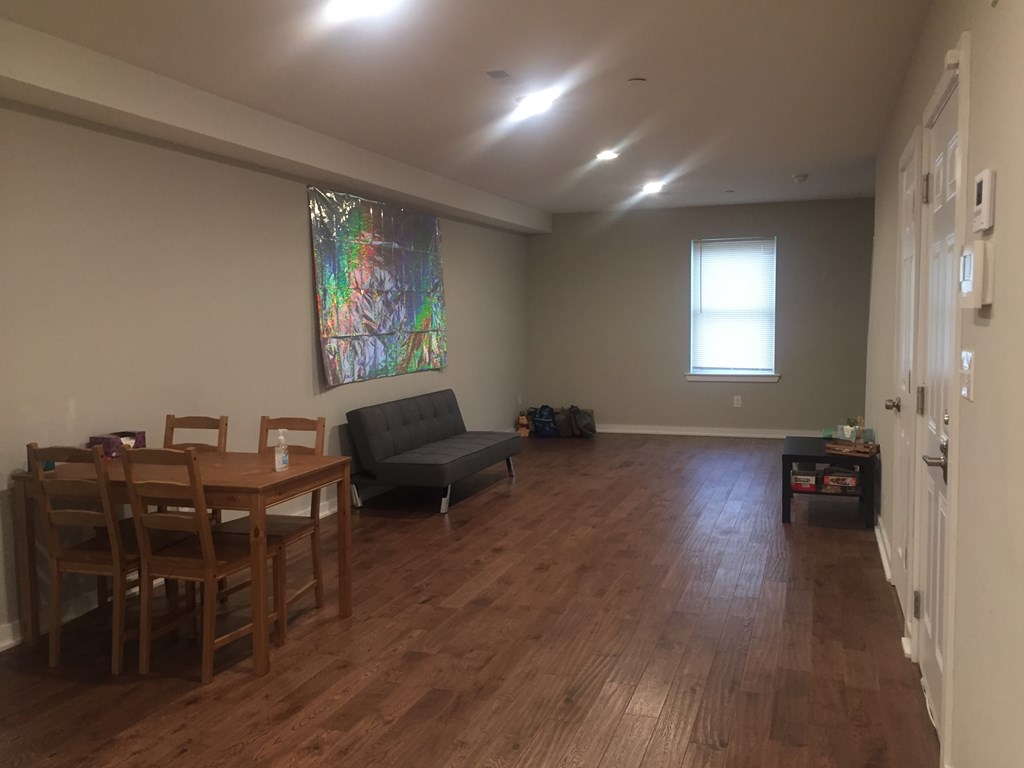 an empty living room with a dining room table and chairs