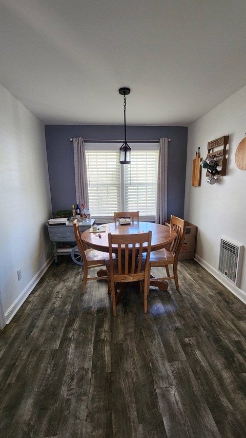 A dining room with a wooden table and chairs.