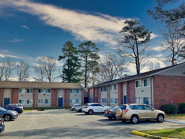 a parking lot with cars in front of an apartment building