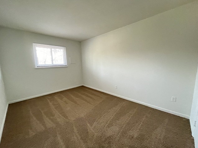 an empty room with carpet and a window