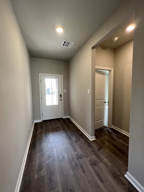 a living room with wood floors and a white door