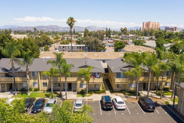 an aerial view of an apartment complex with cars parked in a parking lot
