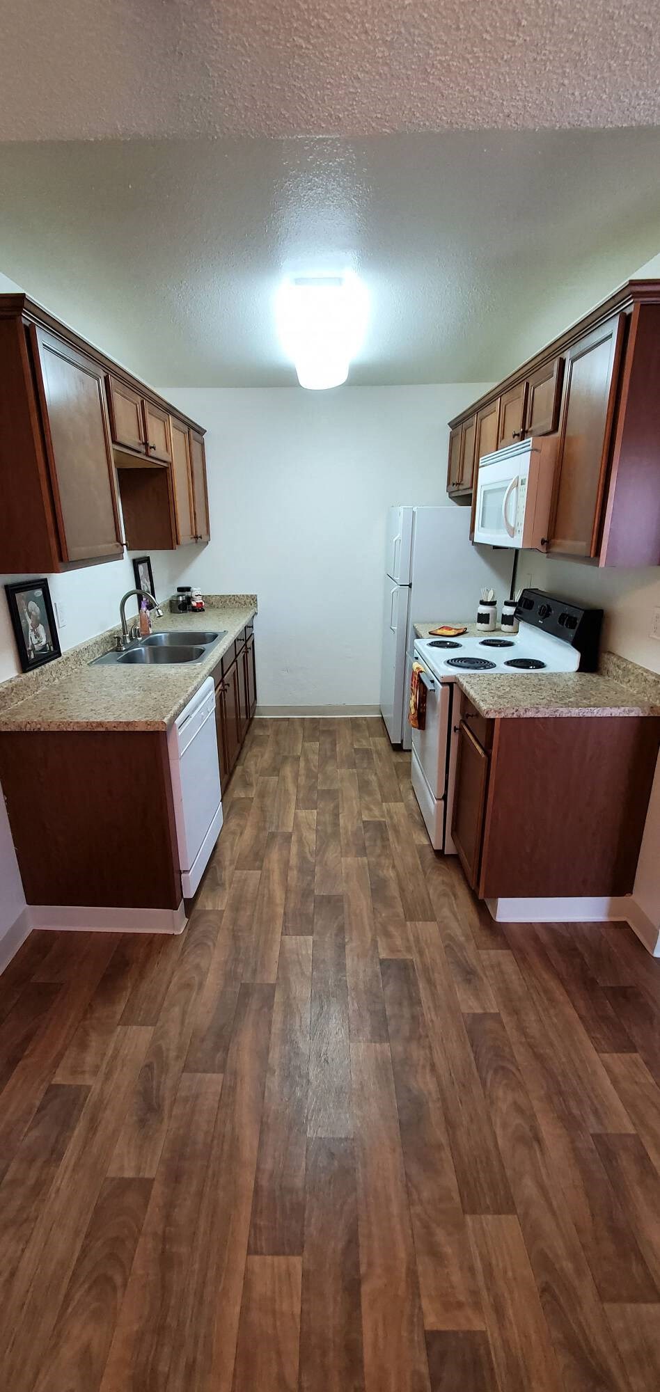 a kitchen with wooden floors and wooden cabinets