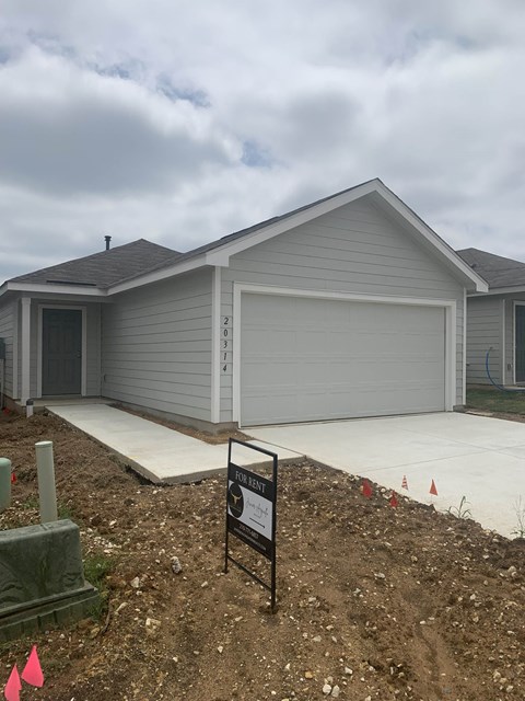 a new house with a sign in front of it