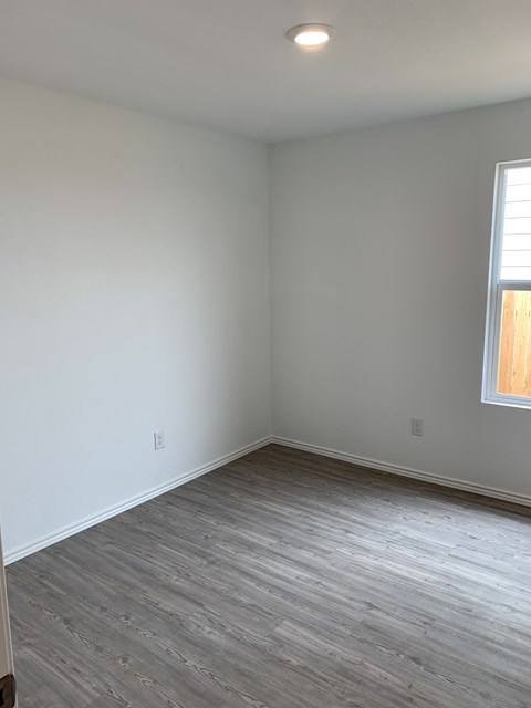 an empty room with white walls and wooden floors