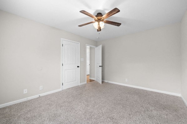 an empty living room with a ceiling fan