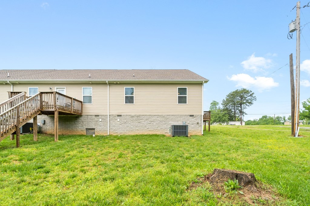 the back of a house with a yard and a staircase