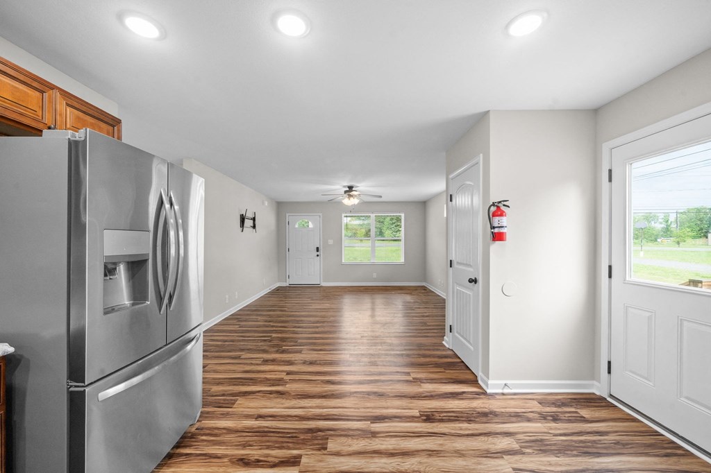 a renovated kitchen with stainless steel appliances and a wooden floor